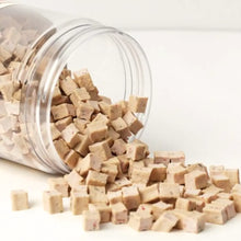 Clear jar filled with small brown cubes on a white background