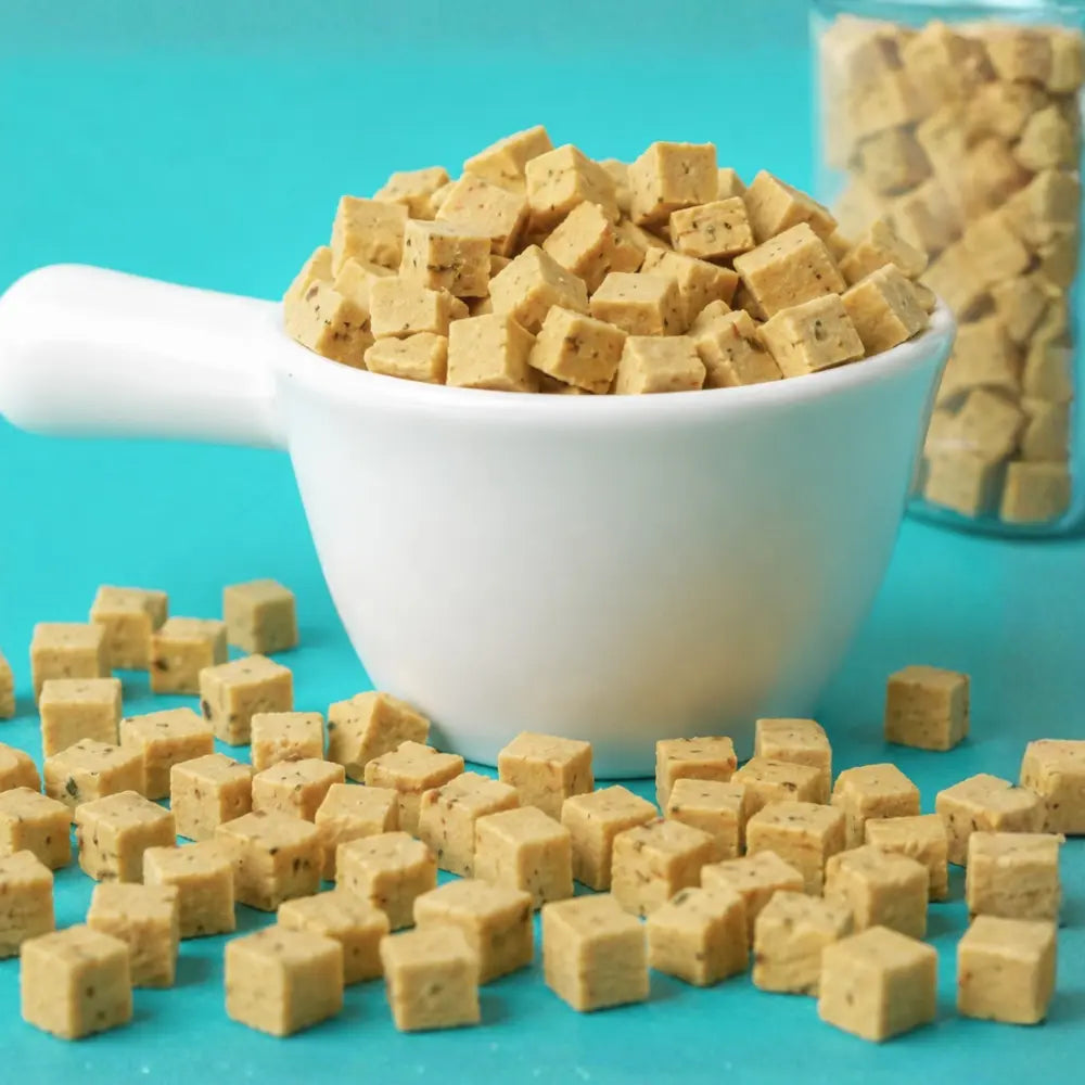 Cubes of tofu in a white bowl on a turquoise background