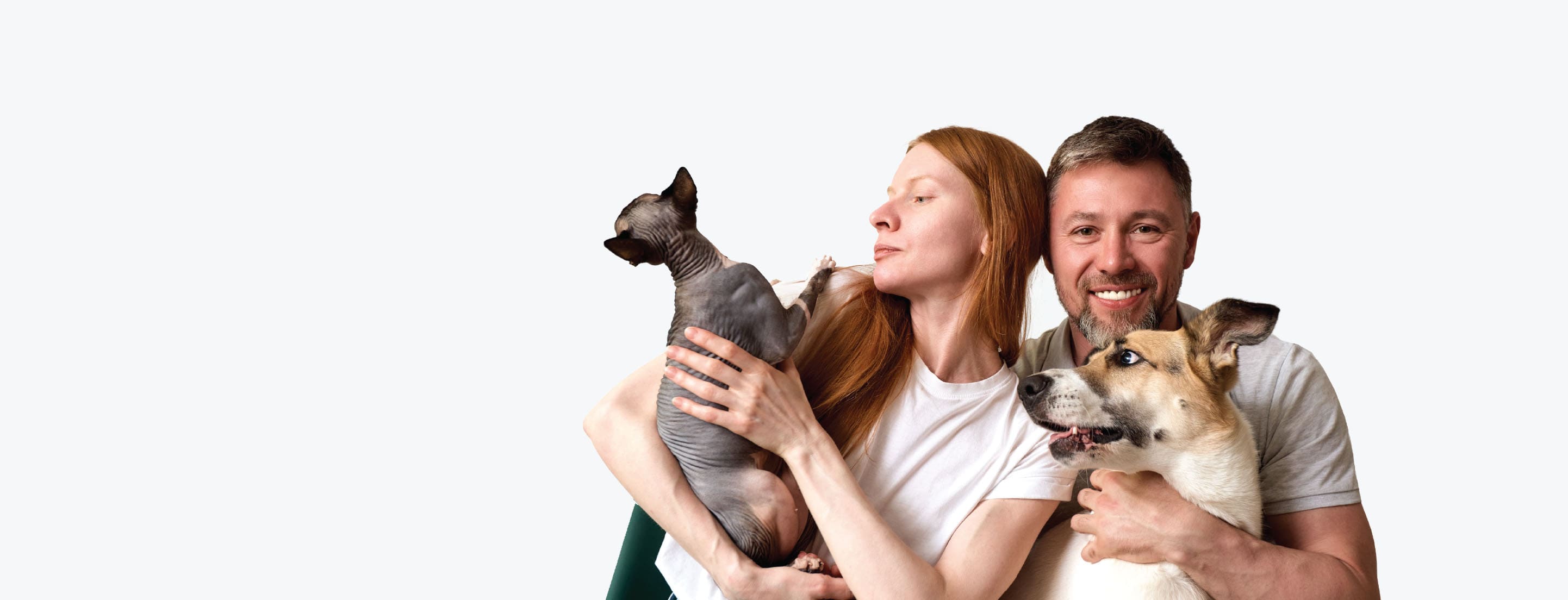 Man and woman holding two dogs against a white background