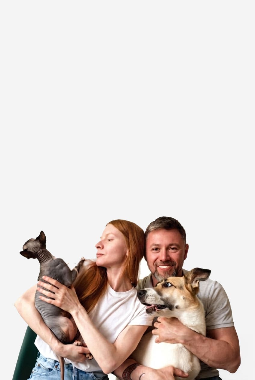 Man and woman holding two dogs against a white background