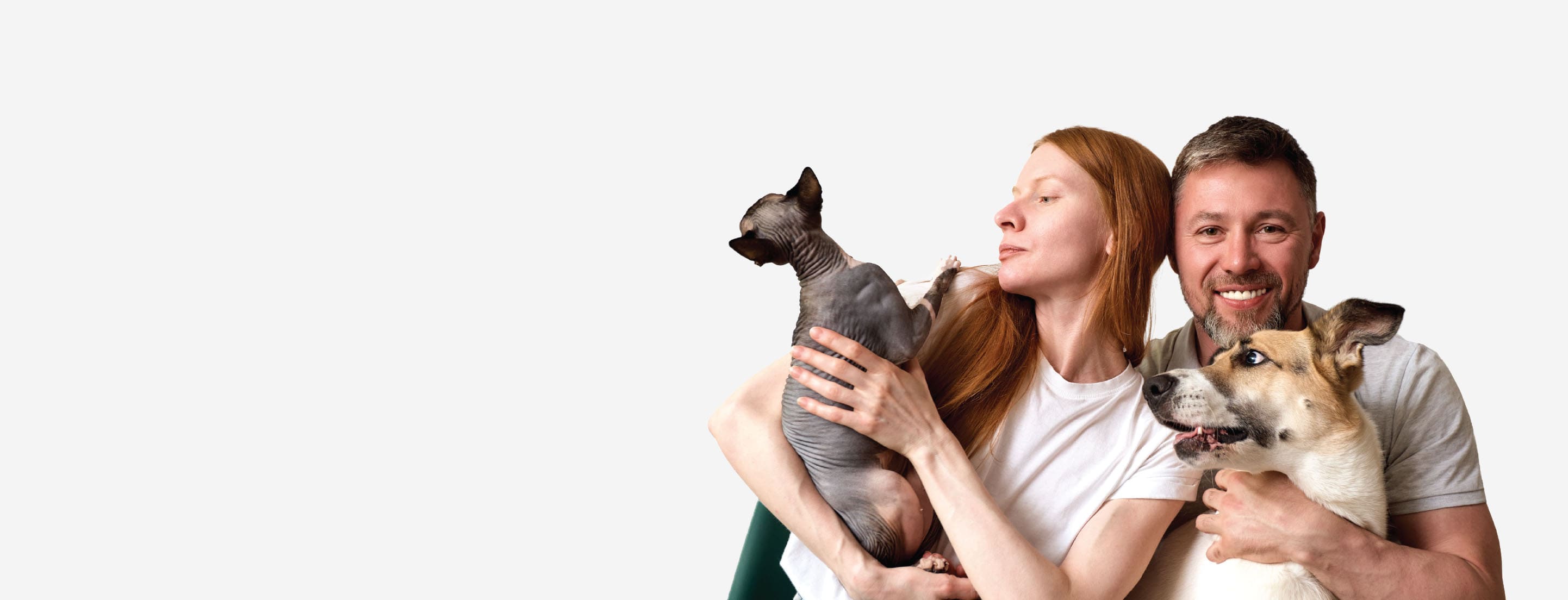 Man and woman holding two dogs against a white background